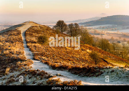 View north from the hill known as The Lawley, Church Stretton, Shropshire  on a cold Winter morning, with The Wrekin hill visible in the mist to the right and with two walkers in the distance. Stock Photo