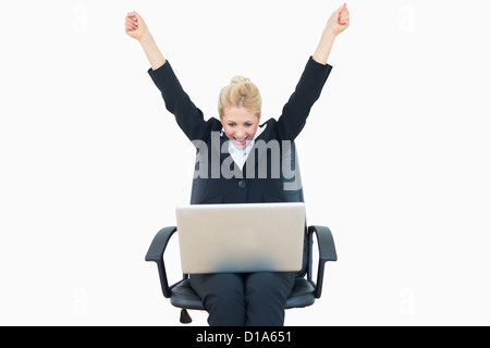 Successful business woman raising hands in victory with laptop Stock Photo