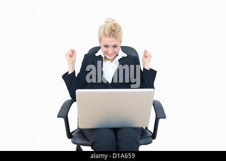 Successful business woman clenching fists in victory with laptop Stock Photo