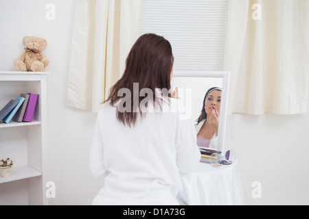 Young woman putting on make-up Stock Photo