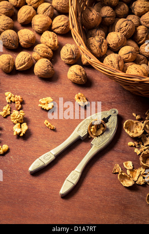 Cracking walnuts on old wooden table Stock Photo