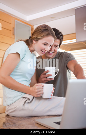 Couple using laptop while drinking coffee Stock Photo