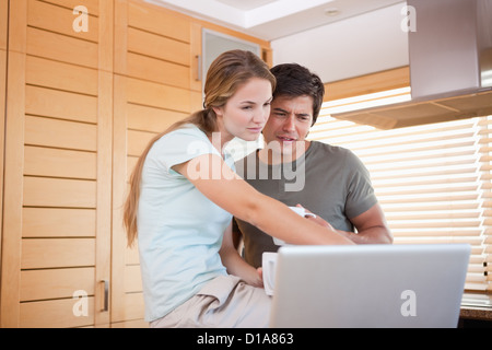 Woman pointing at laptop screen by man Stock Photo
