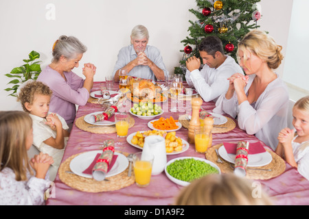 Family saying grace before christmas dinner Stock Photo