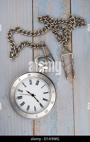Photo of silver vintage pocket watch with chain on wooden background Stock Photo
