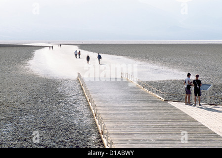 Death Valley National Park, California, USA - Tourists walking on Salt Flats at Badwater Basin, Panamint Mountains beyond Stock Photo