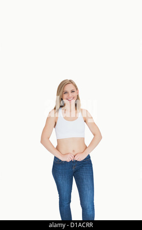 Portrait of slim young woman buttoning jeans Stock Photo