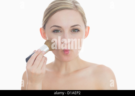 Portrait of young woman putting on make-up Stock Photo