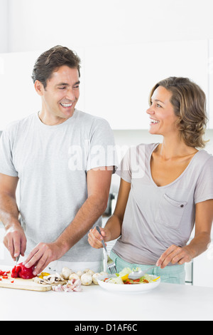 Smiling couple making salad together Stock Photo