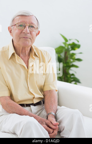Elderly man sitting on the sofa Stock Photo