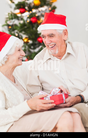 Elderly couple exchanging christmas gifts Stock Photo