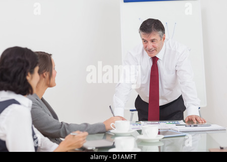 Businessman leaning on desk Stock Photo