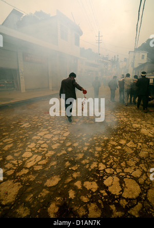 Man Holding Firecrackers During A Funeral Procession, Yuanyang, Yunnan Province, China Stock Photo