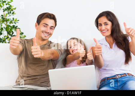 Family giving thumbs up with the laptop Stock Photo