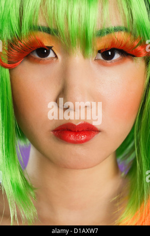 Portrait young woman wearing green wig orange eyelashes over