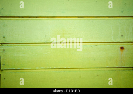 lime green horizontal recently painted wooden planks from beach huts on the seaside. Stock Photo