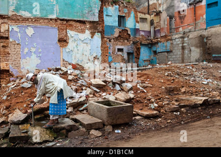 Old Indian man collecting water from a well in Mysore Stock Photo