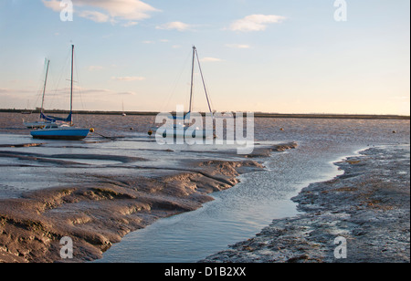 Mudflats outside th Heybridge Lock, Essex, England. At sunrise and low tide with anchored boats and the sea. Stock Photo