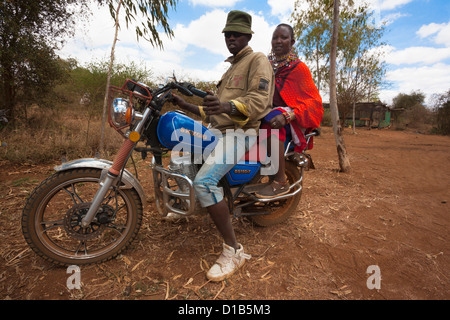 Maasai couple arriving by motorbike at the Predator Compensation Fund Pay Day, Mbirikani Group Ranch,Kenya, Africa, Stock Photo