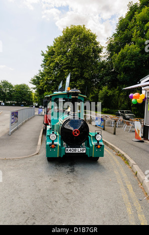 A road train designed to look like a 19th century steam train which carries passengers to and from the car park to Bowness Pier Stock Photo