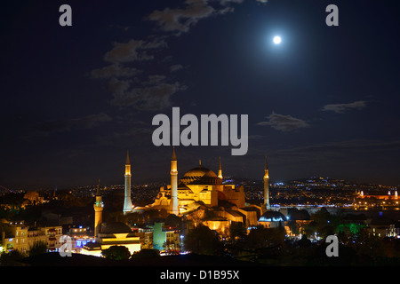 Night lights on Hagia Sophia under a clear full moon rising at night in Istanbul Turkey Stock Photo