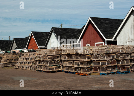 Brightly coloured fish houses and stacks of lobster traps on harbour's edge Stock Photo