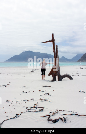 Woman standing at Shipwreck Kakapo at the beach of kommetjie with upcoming storm in the background Stock Photo