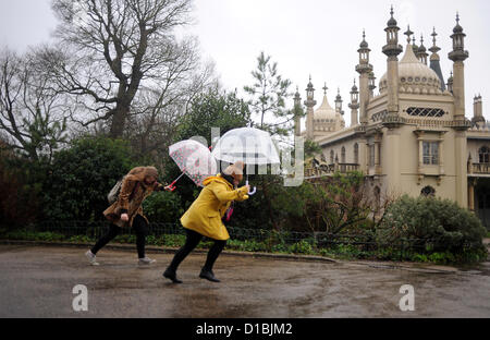 Brighton Sussex UK 14 December 2012 - Students make a dash for it in the pouring rain by the Royal Pavilion in Brighton Stock Photo
