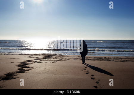 One person alone on a beach in winter in the UK Stock Photo