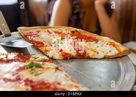 A young woman, girl teenager, eats pizza in a restaurant. Stock Photo
