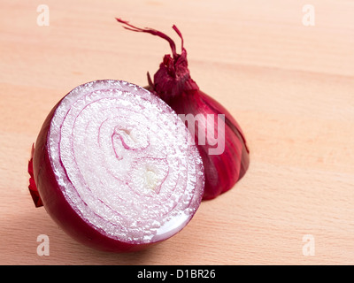 Red onion cut in half on wooden chopping block Stock Photo