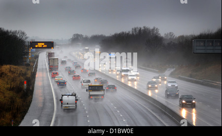 TRAFFIC TRAVELLING ON THE M6 MOTORWAY NEAR STAFFORD IN WET RAINY POOR LIGHT CONDITIONS RE ROAD SAFETY DRIVERS HEADLIGHTS JAMS UK Stock Photo