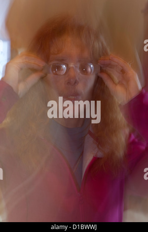 A woman copes with her blurring vision loss with various special classes for assistance reading or watching television Stock Photo