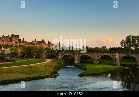 Ancient roman bridge spans wide river in old roman town of Carcassonne France at sunrise Stock Photo