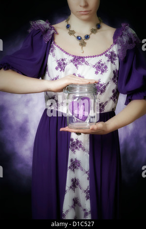 a woman in a period dress is holding a jar with a broken heart