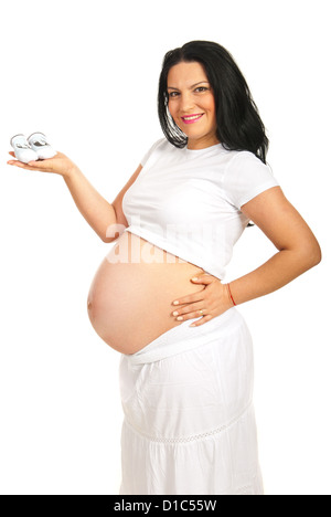 Smiling pregnant woman eight months holding babys bootee isolated on white background Stock Photo