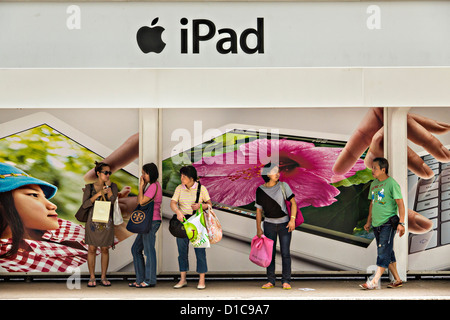 Commuters wait under an iPad advertisement Central District Hong Kong. Stock Photo