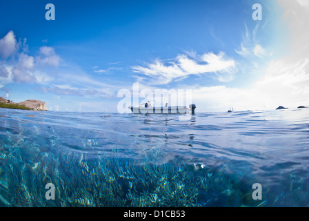 A tender boat in Komodo Marine PArk waiting for the diver to surface. A sunny day with blue sky, sunshine and turquosie water Stock Photo