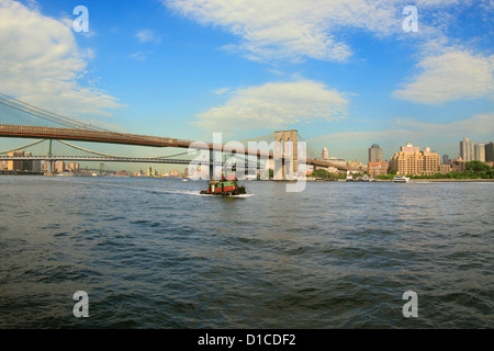 Tugboat on the East River with Brooklyn and Manhattan bridges in background Stock Photo