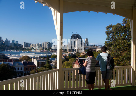 Couple looking out from pavilion in Observatory Park to Sydney Harbour Bridge and Harbour The Rocks Sydney New South Wales Austr Stock Photo