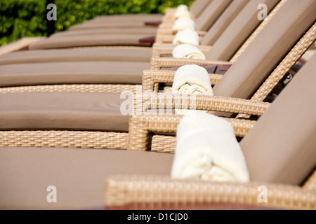 Empty lounge chairs by the poolside Stock Photo