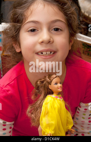 Young pretty girl age 7 playing with her Barbie doll. Chicago Illinois IL USA Stock Photo