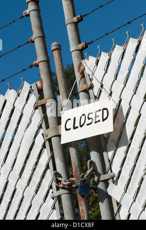 closed sign on padlock chain link fence factory gate Stock Photo