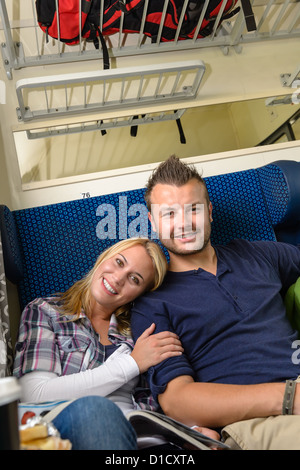 Woman leaning on man's shoulder in train couple smiling traveling Stock Photo