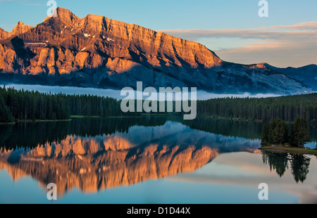 View across two jack lake from Lake Minnewanka Scenic Drive at sunrise in Banff National Park. Stock Photo