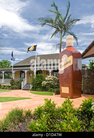 Gigantic bottle of rum and historic cottage at entrance to Bundaberg Rum Distillery Stock Photo