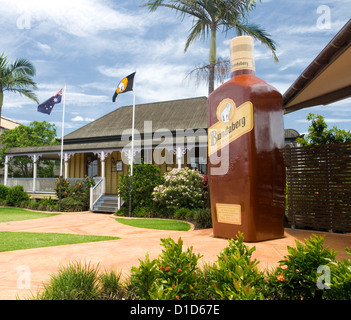 Entrance to Bundaberg rum distillery / bond store tourist attraction with old cottage and gigantic bottle of rum Stock Photo