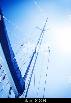 Sailboat in action, big white sail raised over blue clear sky, luxury leisure, summertime activities and extreme sport Stock Photo
