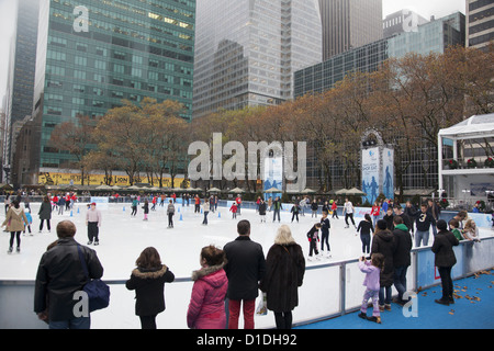 The ice skating rink is always busy in Bryant Park during the holiday season behind the NY Public Library in NYC. Stock Photo