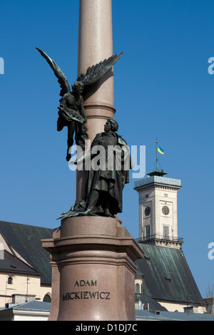 Adam Mickiewicz monument in Lviv, Ukraine. Town Hall with national flag on background. Stock Photo